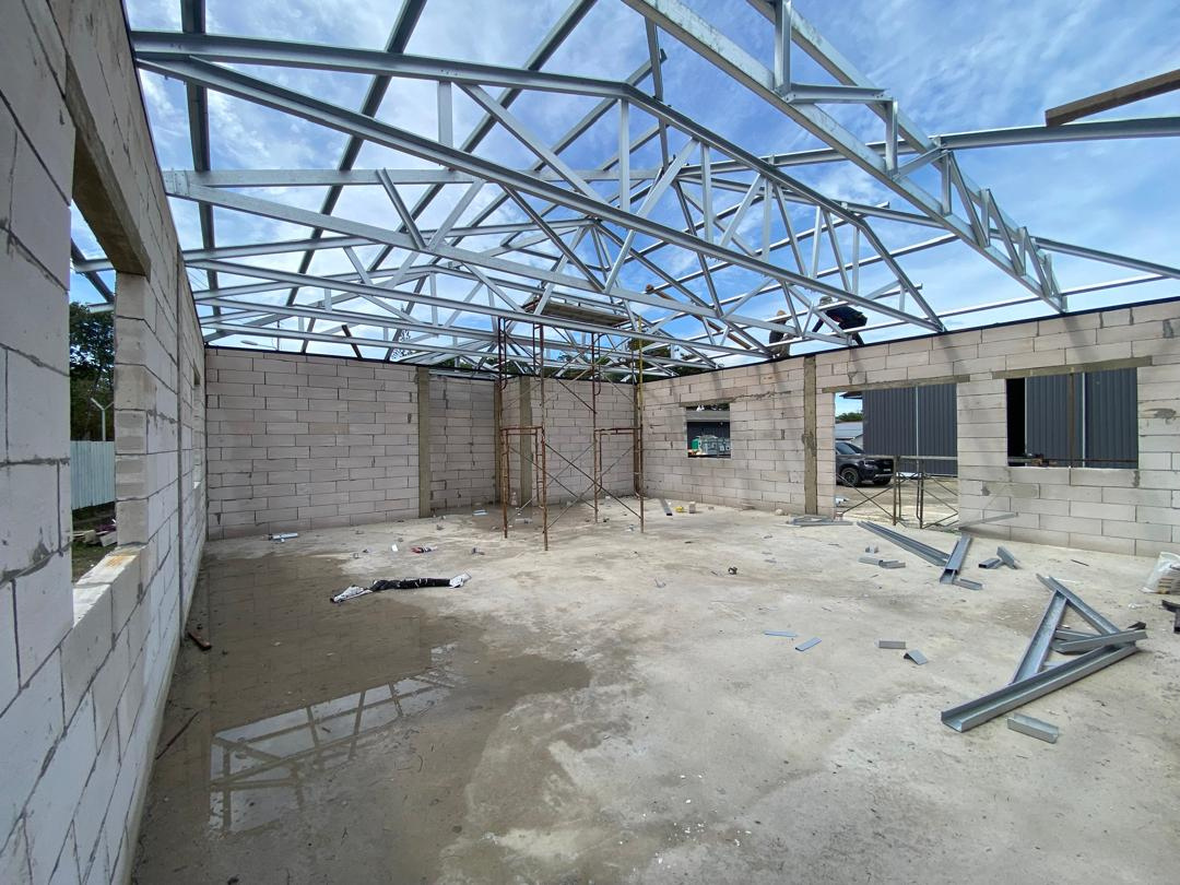 Steel roof truss installation in progress